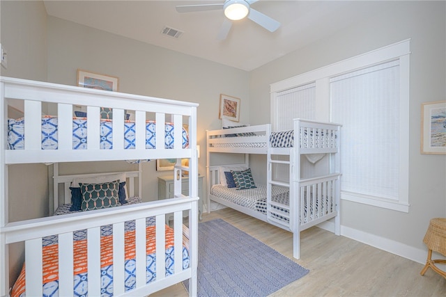 bedroom featuring baseboards, visible vents, and wood finished floors