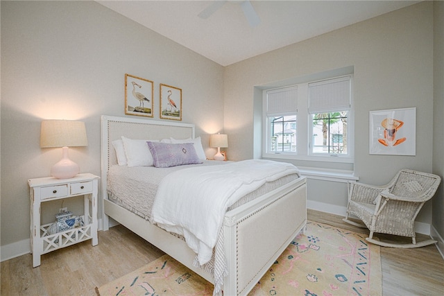 bedroom featuring a ceiling fan, light wood-style flooring, and baseboards