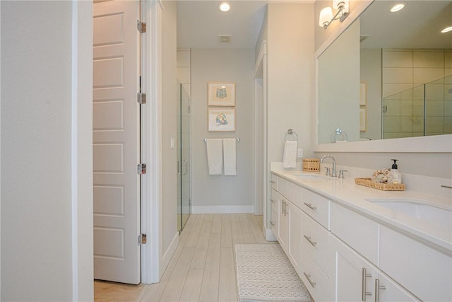 full bathroom featuring a stall shower, a sink, recessed lighting, and wood finished floors