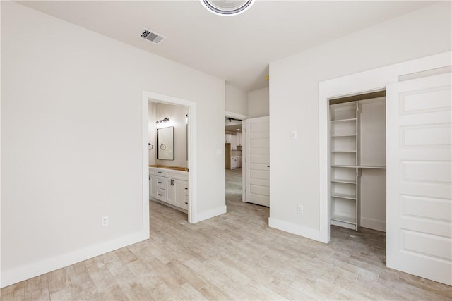 15638 Escapade St, Corpus Christi, TX 78418 - unfurnished bedroom featuring light wood-style floors, a walk in closet, ensuite bathroom, and a closet