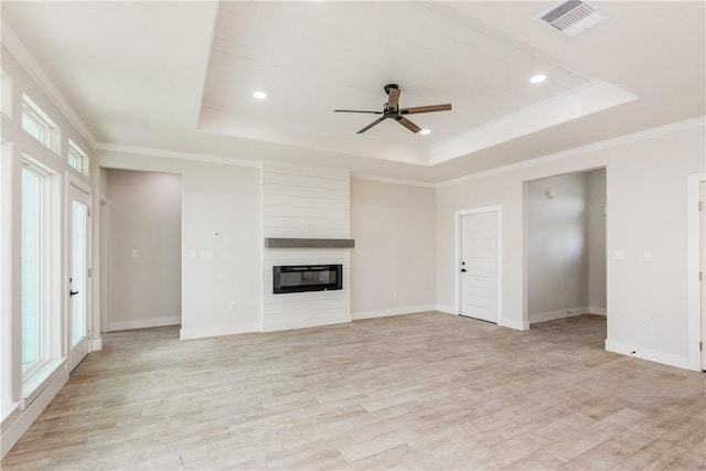 15638 Escapade St, Corpus Christi, TX 78418 - unfurnished living room featuring a tray ceiling, a ceiling fan, healthy amount of natural light, light wood-style flooring, and crown molding