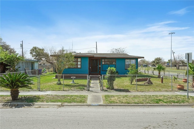 view of front facade featuring a fenced front yard, a front lawn, and a gate