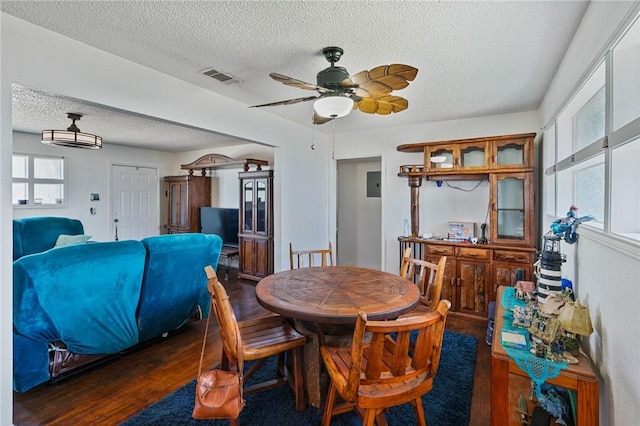 dining area with visible vents, a textured ceiling, ceiling fan, and wood finished floors