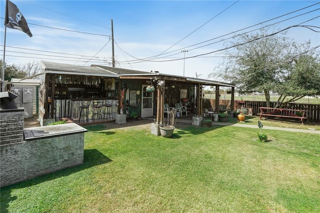 view of yard with fence and outdoor dry bar