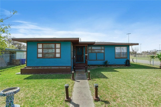 view of front of house with a front lawn and fence