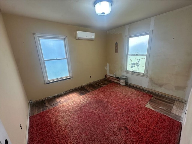 225 W Gile Ave, Aransas Pass, TX 78336 - empty room with a wall mounted AC, a healthy amount of sunlight, and wood finished floors