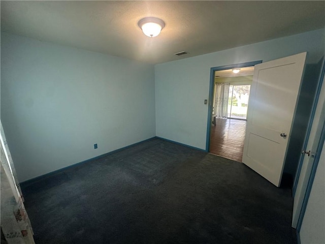 225 W Gile Ave, Aransas Pass, TX 78336 - spare room featuring baseboards, dark colored carpet, and visible vents