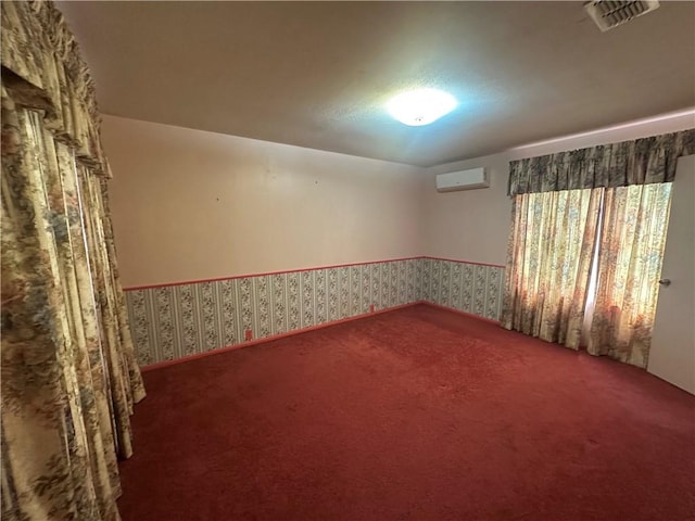 225 W Gile Ave, Aransas Pass, TX 78336 - empty room with wallpapered walls, visible vents, a wall unit AC, and carpet