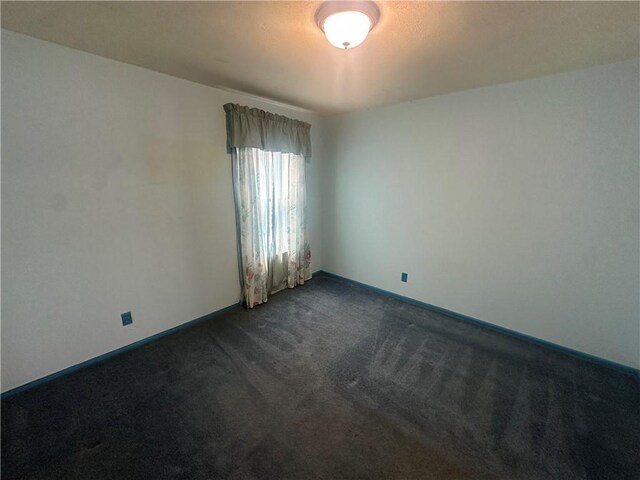 225 W Gile Ave, Aransas Pass, TX 78336 - unfurnished room featuring baseboards and dark carpet