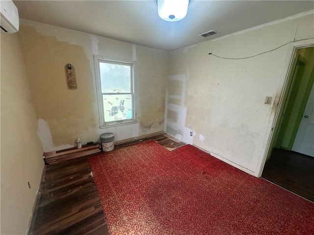 225 W Gile Ave, Aransas Pass, TX 78336 - spare room with dark wood-type flooring, an AC wall unit, and visible vents