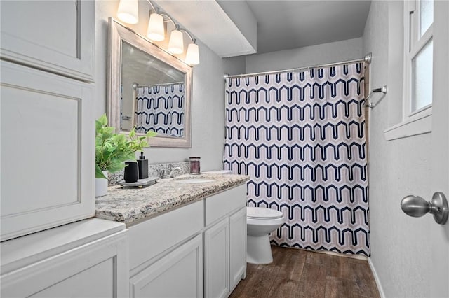 bathroom featuring hardwood / wood-style flooring, vanity, curtained shower, and toilet