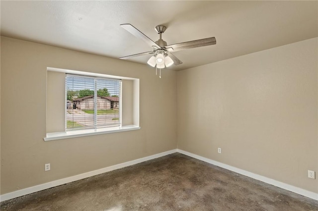 empty room featuring concrete floors, a ceiling fan, and baseboards