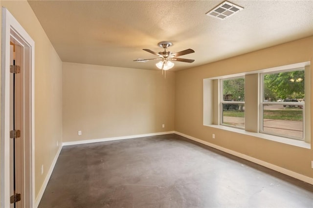 unfurnished room with baseboards, visible vents, concrete floors, and ceiling fan