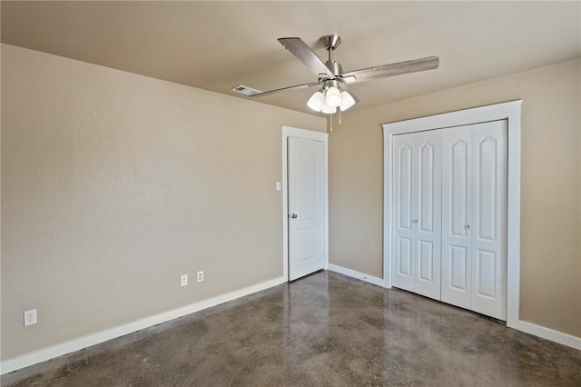 unfurnished bedroom with concrete flooring, a closet, visible vents, and baseboards