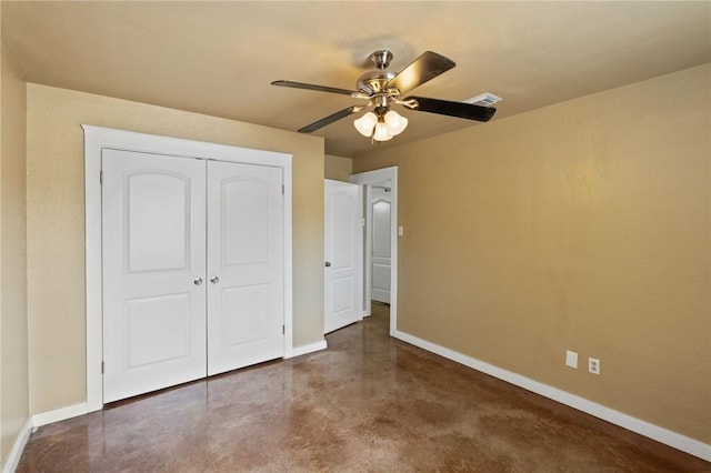 unfurnished bedroom featuring visible vents, baseboards, finished concrete flooring, a ceiling fan, and a closet