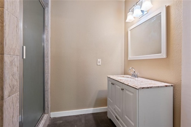 full bathroom featuring baseboards, vanity, and a tile shower