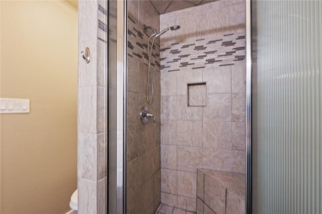 bathroom featuring toilet and a stall shower
