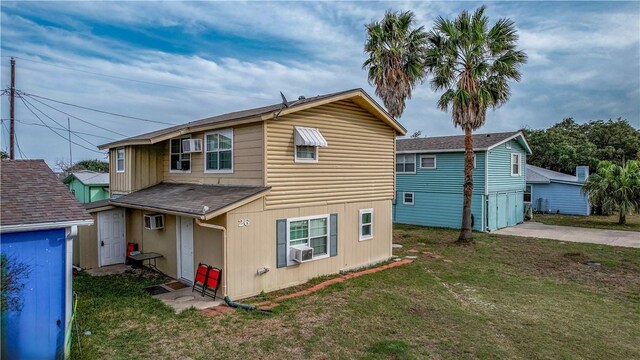 26 Bayberry Cir, Rockport, TX 78382 - back of house with a lawn, cooling unit, and a wall mounted air conditioner