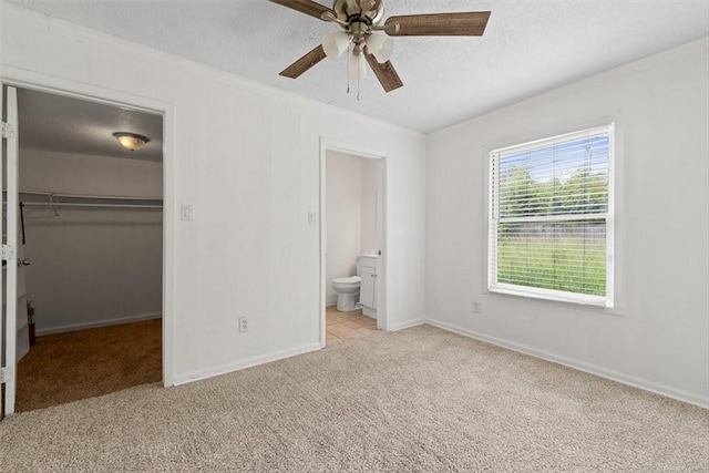2853 Lawnview St, Corpus Christi, TX 78404 - unfurnished bedroom with carpet flooring, a walk in closet, a closet, ensuite bath, and ceiling fan