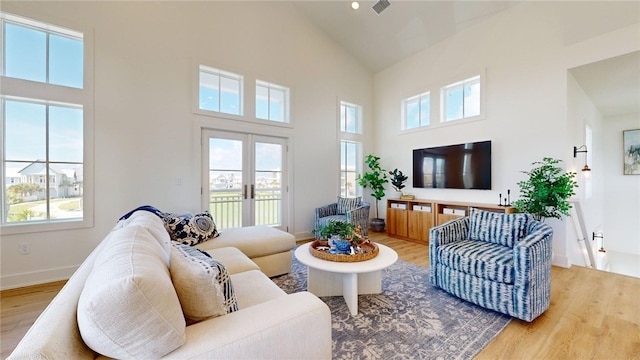 living room featuring french doors, plenty of natural light, and wood finished floors
