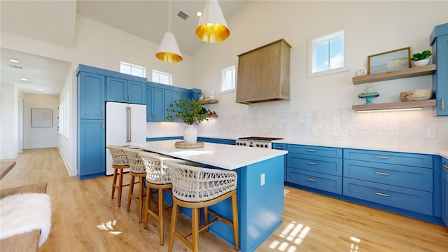 kitchen featuring a breakfast bar, blue cabinetry, and open shelves