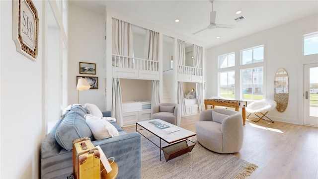living room with visible vents, a high ceiling, ceiling fan, recessed lighting, and wood finished floors