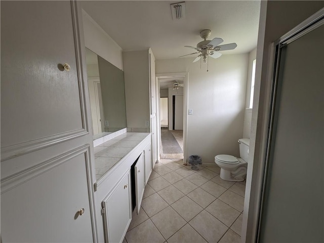 bathroom with tile patterned floors, vanity, ceiling fan, and toilet