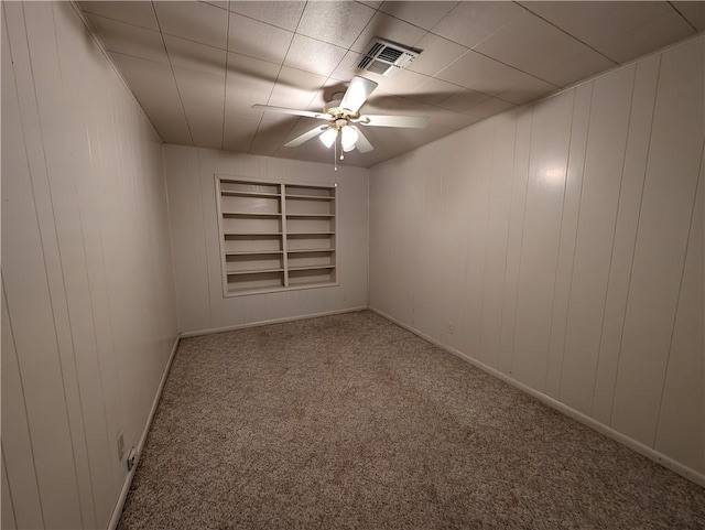 unfurnished room featuring carpet, ceiling fan, and built in features