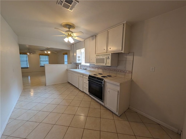 kitchen with white cabinets, range with electric cooktop, ceiling fan, light tile patterned floors, and tasteful backsplash