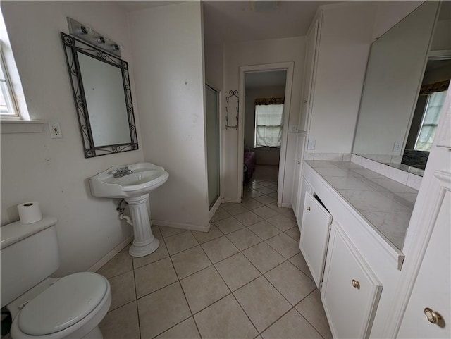 bathroom with tile patterned flooring, toilet, and a shower with shower door