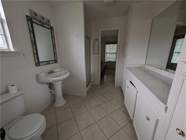 bathroom with tile patterned floors, toilet, and walk in shower