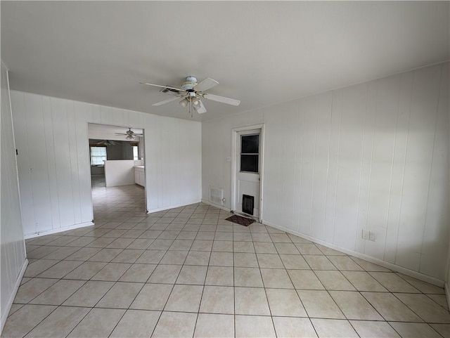 tiled empty room featuring ceiling fan