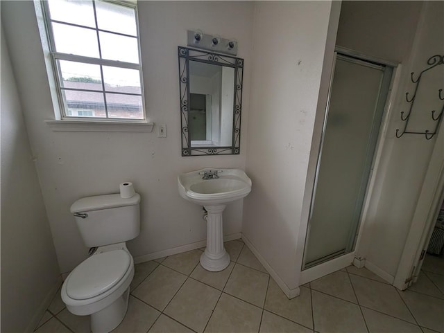 bathroom with tile patterned flooring, a shower with shower door, and toilet