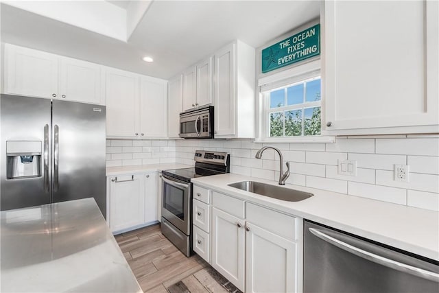 kitchen featuring white cabinetry, appliances with stainless steel finishes, sink, and tasteful backsplash