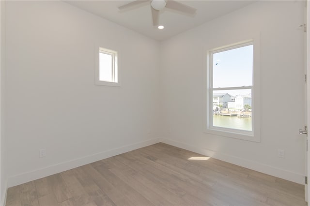 spare room featuring plenty of natural light, light hardwood / wood-style floors, and ceiling fan