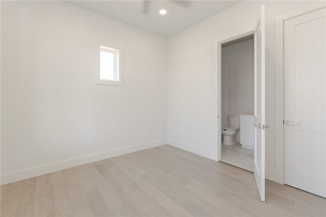 unfurnished bedroom featuring ensuite bathroom, light hardwood / wood-style floors, and ceiling fan