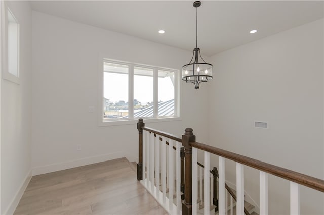 hallway with a chandelier and light hardwood / wood-style flooring