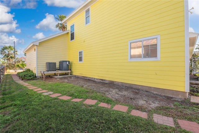 view of home's exterior with a yard and central AC