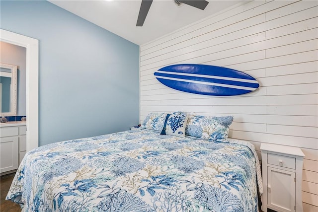 bedroom featuring a ceiling fan, lofted ceiling, wooden walls, and wood finished floors