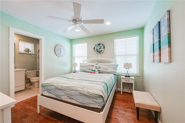 bedroom featuring wood finished floors, baseboards, recessed lighting, ceiling fan, and connected bathroom