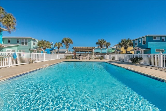 pool with a patio area, a residential view, a pergola, and fence