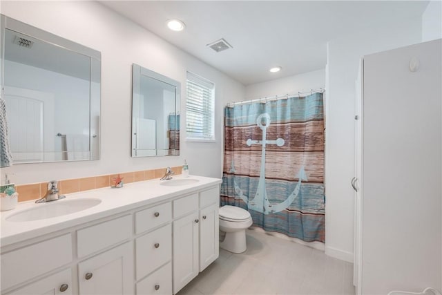 full bath with a sink, visible vents, toilet, and double vanity