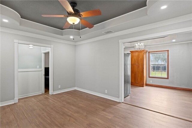 4446 Naples St, Corpus Christi, TX 78415 - empty room featuring visible vents, a tray ceiling, light wood-style flooring, and crown molding