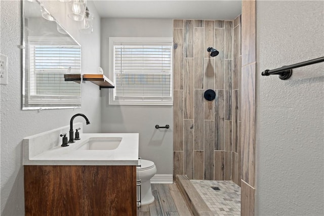4446 Naples St, Corpus Christi, TX 78415 - full bathroom with toilet, a tile shower, vanity, wood finished floors, and baseboards