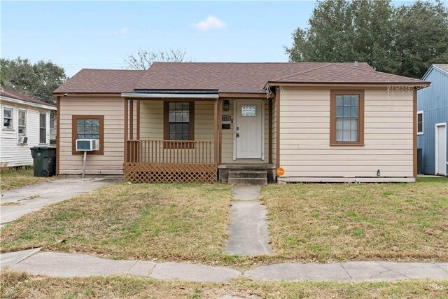 view of front of home featuring a front yard, covered porch, roof with shingles, and cooling unit