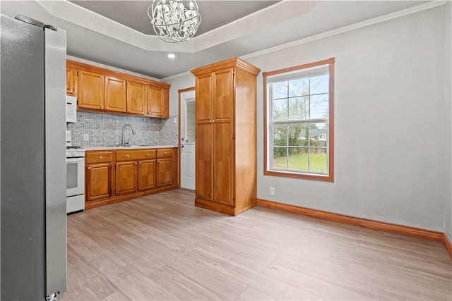 4446 Naples St, Corpus Christi, TX 78415 - kitchen featuring a tray ceiling, decorative light fixtures, light countertops, a sink, and white appliances