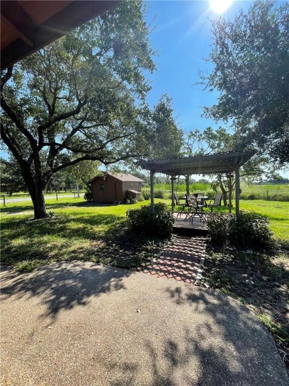 view of yard featuring a pergola, a shed, and a patio area