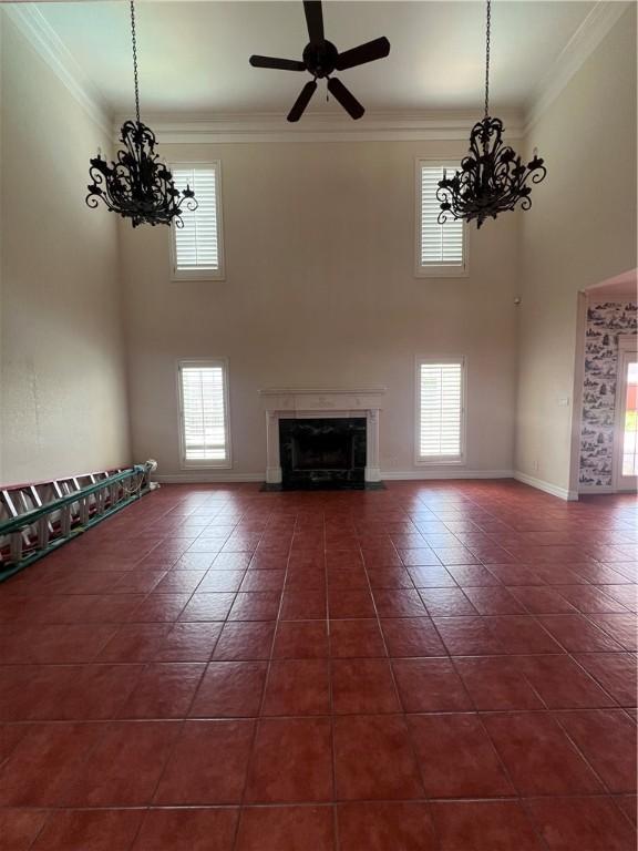 4502 Thoreau Cir, Corpus Christi, TX 78410 - unfurnished living room with a chandelier, a high ceiling, a high end fireplace, ornamental molding, and a ceiling fan