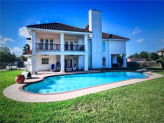 4502 Thoreau Cir, Corpus Christi, TX 78410 - rear view of house featuring a balcony, a patio area, a chimney, a tile roof, and stucco siding