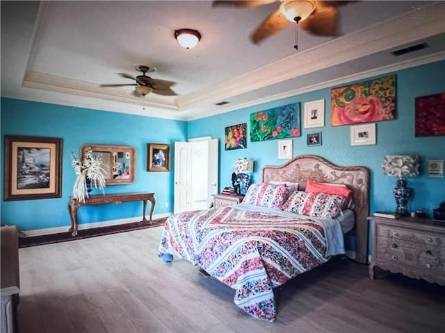 4502 Thoreau Cir, Corpus Christi, TX 78410 - bedroom with ornamental molding, a tray ceiling, wood finished floors, and ceiling fan